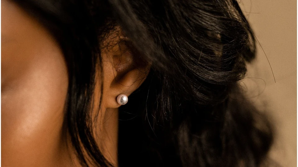 Close-up of a BLOMDAHL pearl earring worn on the ear