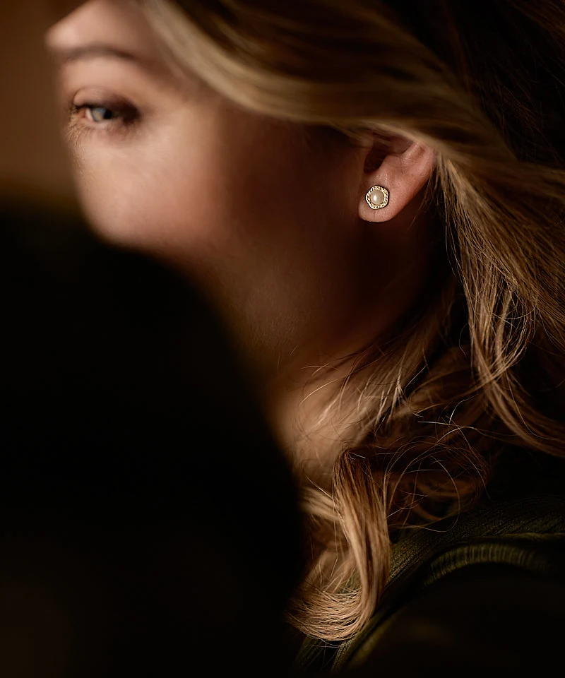 Portrait of a woman wearing a BLOMDAHL gold-tone pearl earring