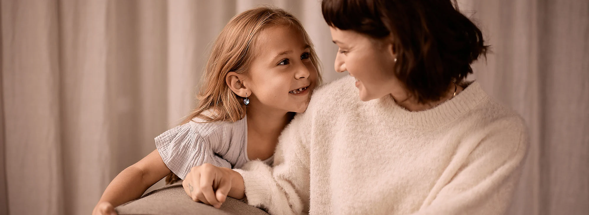 A mother and child sharing a moment wearing BLOMDAHL jewellery